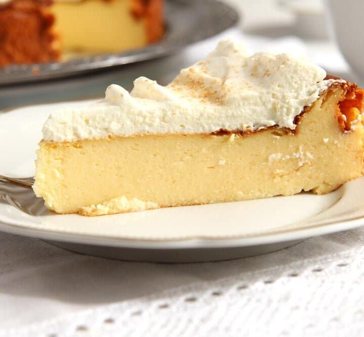 easy crustless cheesecake with whipped cream sliced on a small vintage plate.