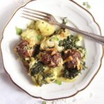 serving spinach potato bake with meatballs on a plate