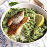 spinach and potato mash in a small bowl with fish.