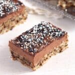 square of romanian queen mary cake with chocolate buttercream and sugar pearls.