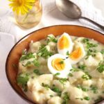 cauliflower florets topped with boiled eggs in a brown bowl