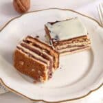 two square pieces of romanian greta garbo cake on a vintage white plate.