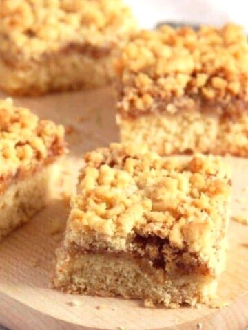 apricot jam cake with crumbles cut into squares.