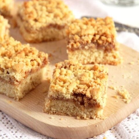 apricot jam cake on a wooden board cut into pieces