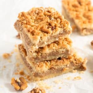 apricot jam cake, three pieces stapled on the table and some walnut pieces.
