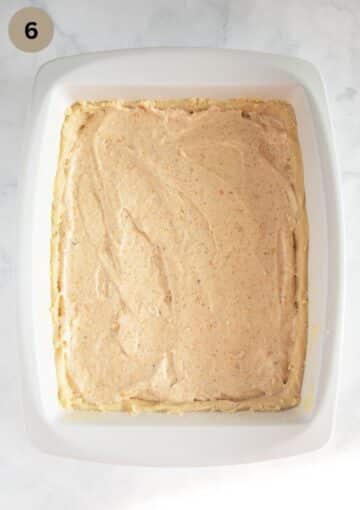 layering cake dough with apricot jam and egg white filling.