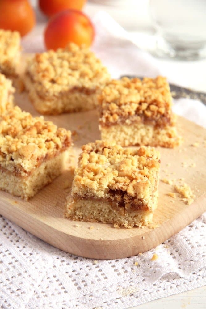 apricot jam cake on a wooden board cut into pieces