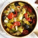 leek stew with olives in a small clay pot.