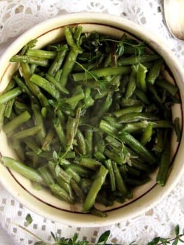 romanian green beans with garlic sauce in a rustic bowl.