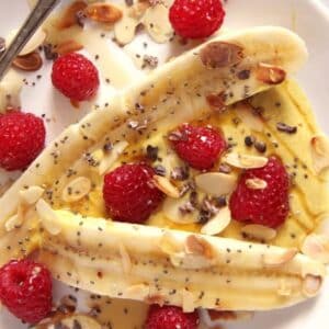 healthy banana split with fresh raspberries and honey close up.