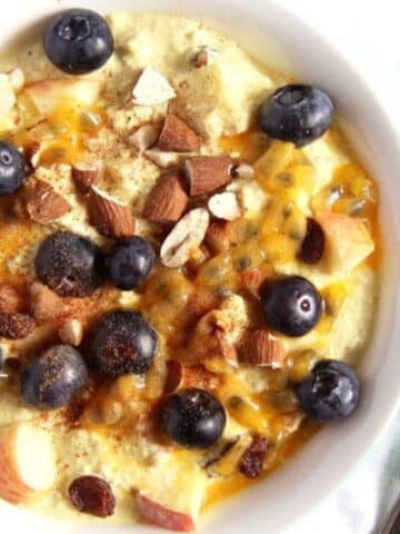 muesli with yogurt, blueberries, almonds, apples and cinnamon in a bowl.