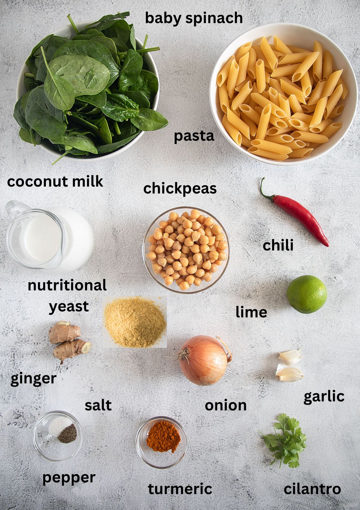 labeled ingredients for making pasta with turmeric, spinach, coconut milk and chickpeas on the table.