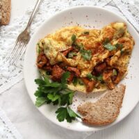 chanterelle omelet with rosemary on a small plate with bread