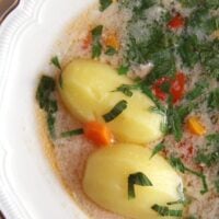 fish soup with whole potatoes in it.