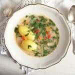 romanian fish soup with two whole cooked potatoes and lots of parsley in it.