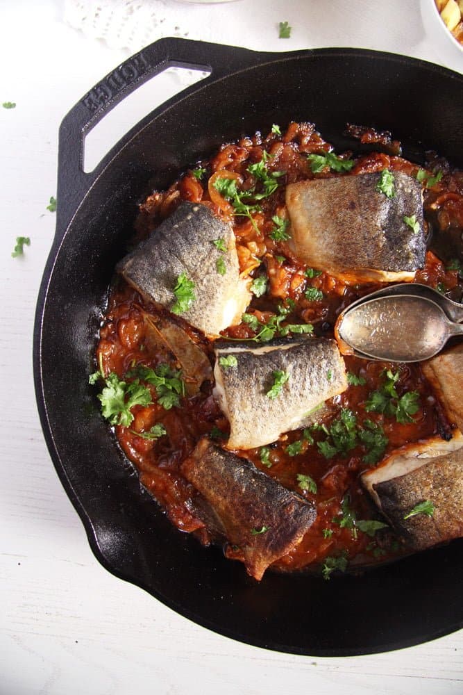 trout pieces in a skillet with onions