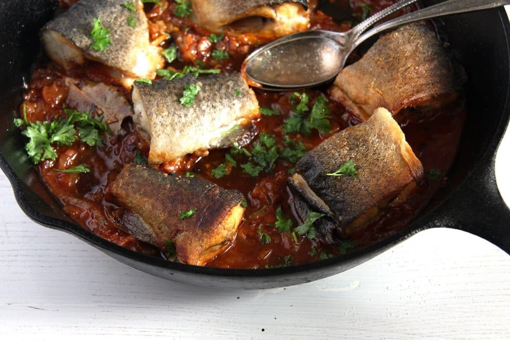 trout pieces in a skillet with onions