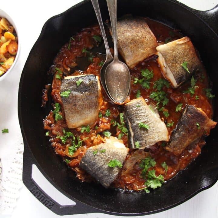 stewed trout with tomatoes in a skillet served with polenta in a bowl
