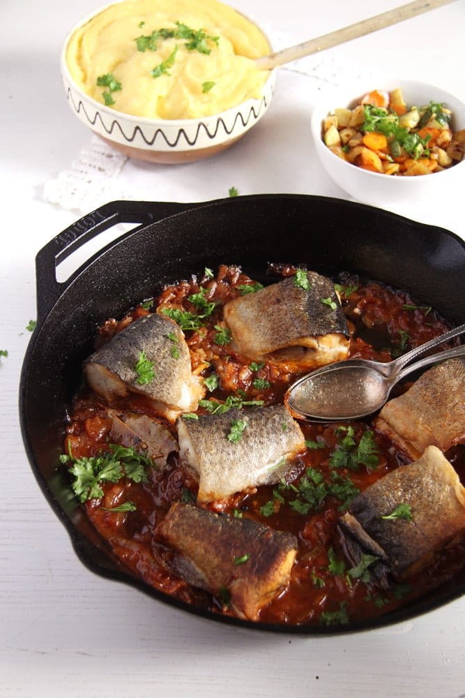 trout pieces in a skillet with onions