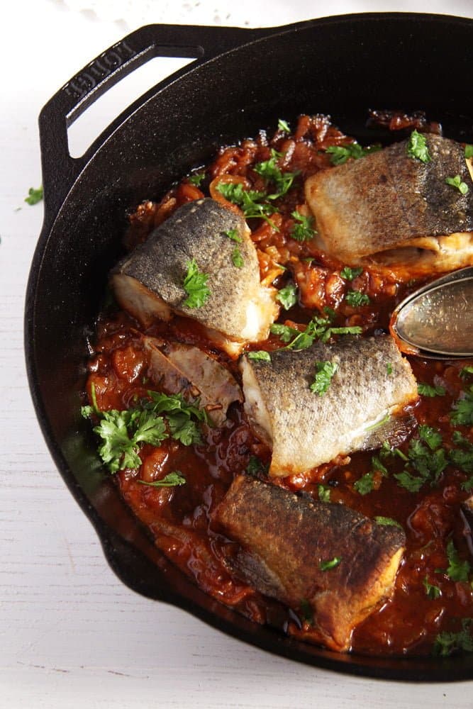 trout pieces in a skillet with onions