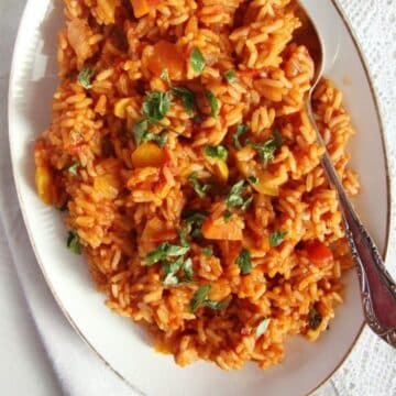 vegan rice with tomatoes and veggies served on a large vintage platter.