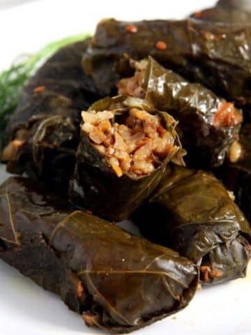 vegetarian stuffed vine leaves with rice and dill, one showing the filling.