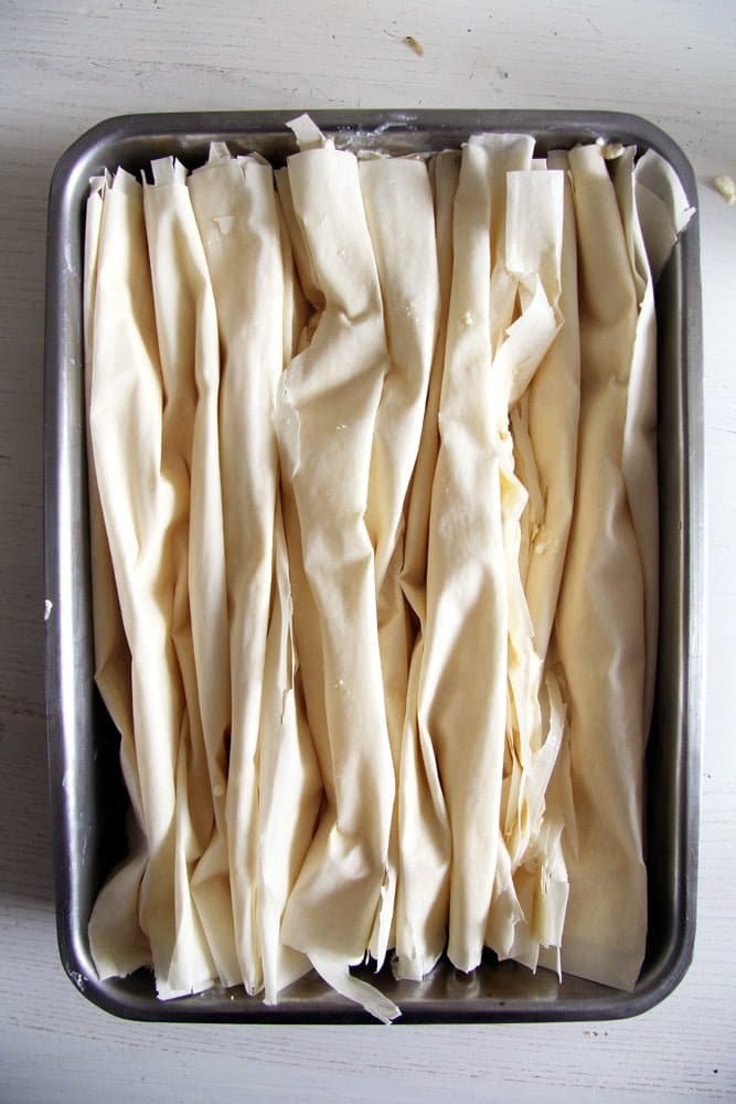 unbaked filo pastry filled with cheese in a baking tin