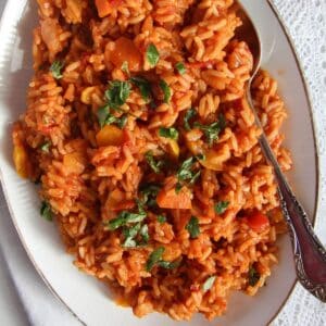 plate with zucchini tomato rice with a spoon in it.