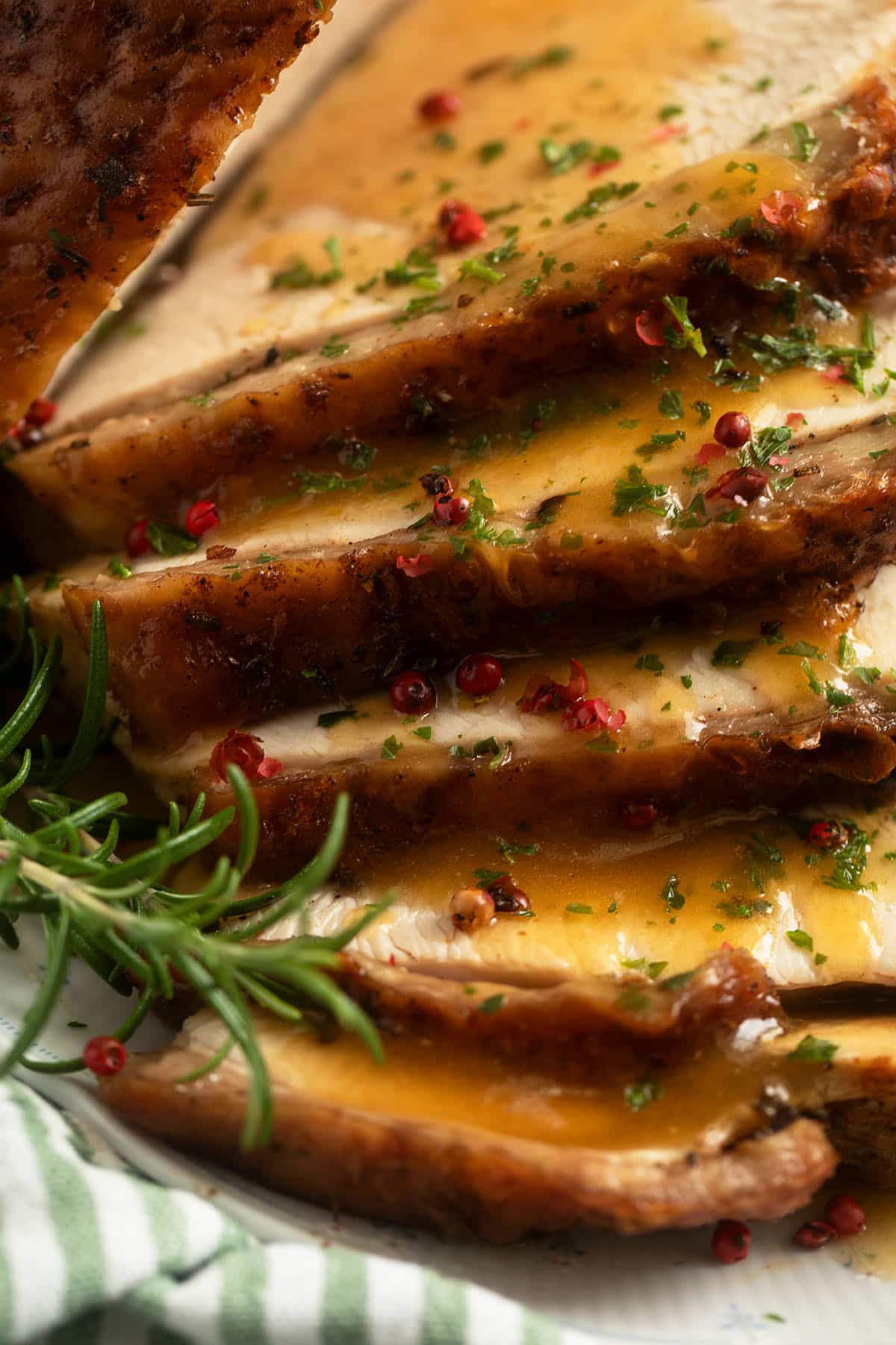close up slices of turkey breast slathered with gravy.