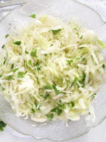 white cabbage salad sprinkled with fresh chopped parsley in a vintage bowl.