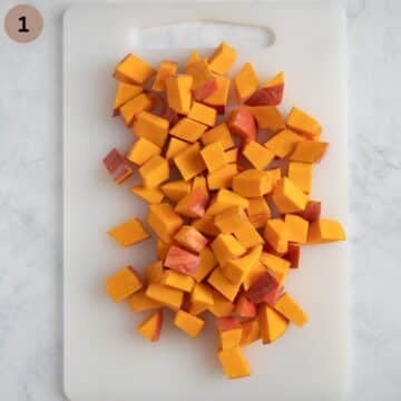 chopped pumpkin pieces on a cutting board.