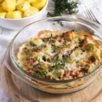 creamy cheesy brussels sprouts casserole with parmesan being served