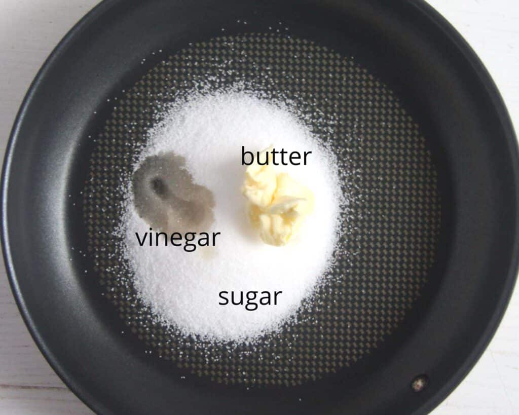 black pan containing sugar, butter and vinegar for making caramel.