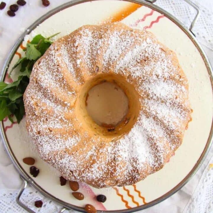 egg white cake sprinkled with icing sugar on a vintage platter.