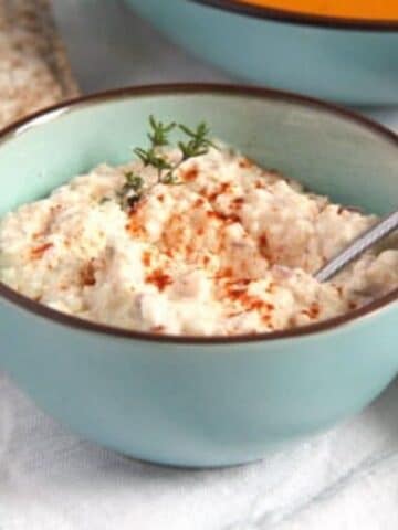 korozott or hungarian appetizer dip with cheese and paprika in a blue bowl.