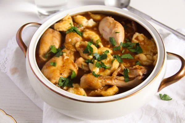 vintage bowl with romanian paprikash with dumplings and chicken legs.