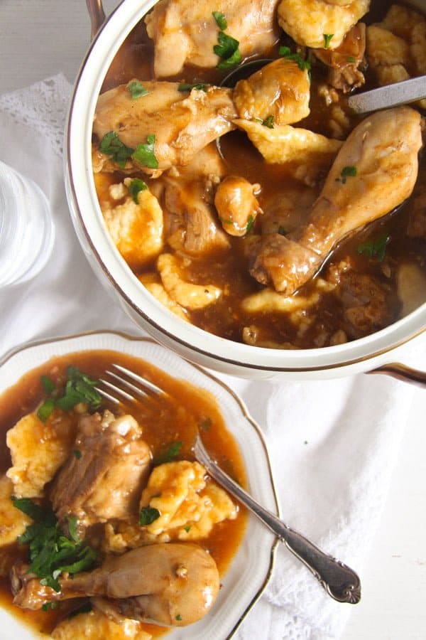 bowl and plate with chicken cooked in paprika and served with dumplings.