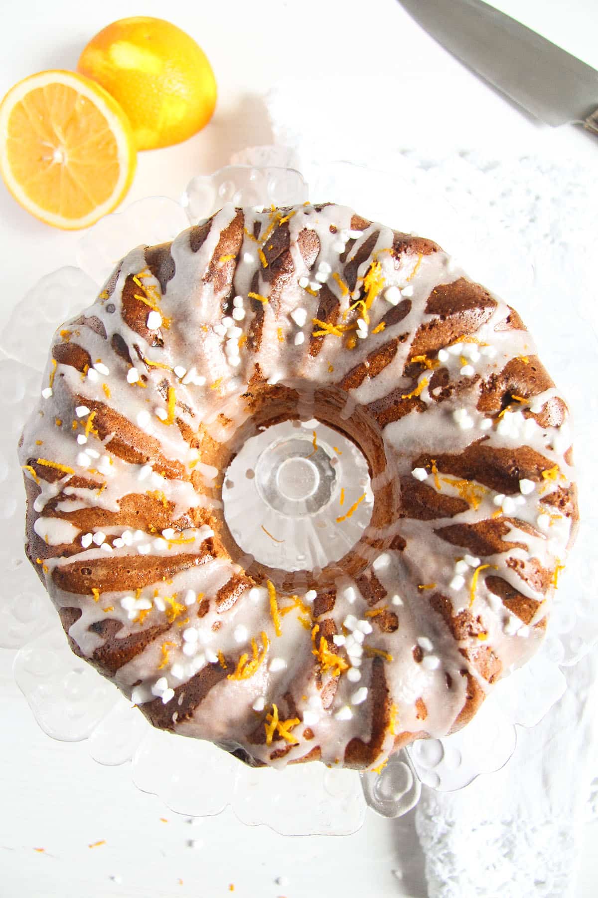 bundt cake with orange and raisins and a halved orange near it.
