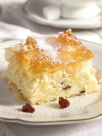 a piece of vargabeles dessert with filo, raisins and noodles on a plate.