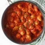 a saucepan full of pork meatballs in tomato sauce.