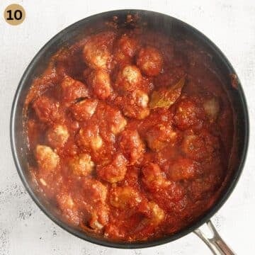 pork meatballs cooked in tomato sauce in a large pan.