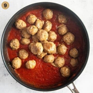 adding small pork meatballs to tomato sauce in a large saucepan.