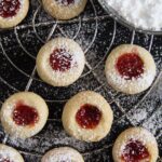 classic thumbprint cookies with jam on a wire rack.