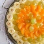 vanilla pudding tart with bananas, grapes and mandarins close up.