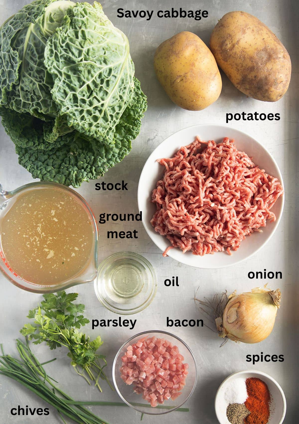 labeled ingredients for making german soup with savoy cabbage, ground meat, bacon and potatoes.