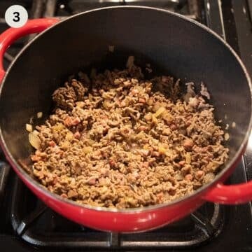cooking ground meat to make cabbage soup in a dutch oven.