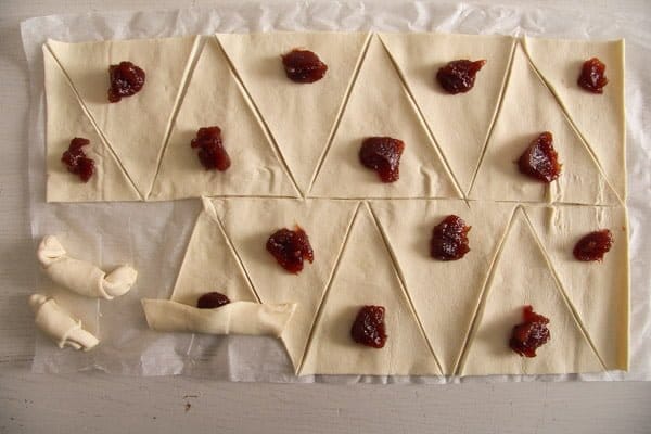 cutting puff pastry into triangles and filling them with jam