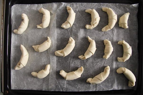 unbaked mini puff pastry croissants on a baking tray
