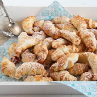 dozens of mini croissants with jam on a blue napkin