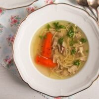 a plate with rosol polish soup with carrots and noodles